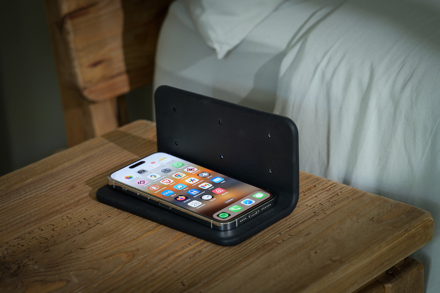 Phone under The Sleep Shield EMF-blocking cover beside bed