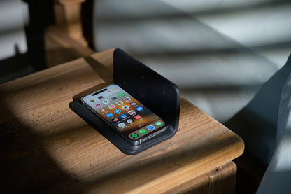 Phone under The Sleep Shield EMF-blocking cover beside bed